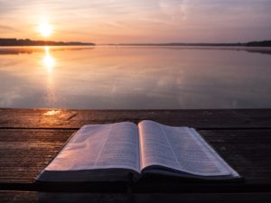 Bible surrounded by sunset on a beach